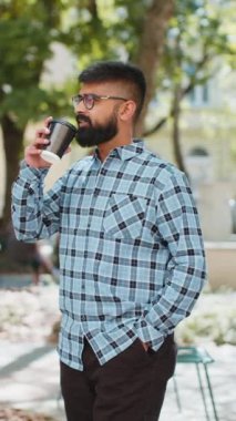 Mutlu Hintli sakallı adam sabah kahvesinin tadını çıkarıyor sıcak bir şeyler içiyor ve dışarıda gülümsüyor. Dinleniyorum, ara veriyorum. Şehir caddesinde dikilen İspanyol adam kahve içiyor. Kasaba yaşam tarzları. Dikey