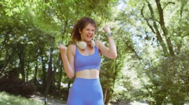 Atletik formda koşucu kız başarıyı kutluyor zafer çığlığı zafer maratonunu kutluyor. Sunny Park 'ta kardiyo eğitimi. Genç bir kadın sağlıklı yaşam tarzını seviyor. Aktif sporcu kadın motivasyonu.