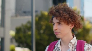 Mutlu turist yüzünün yakın plan portresi gülümseyen dost canlısı, mutlu bakışlar rüya gören rahatlama, dışarıda iyi haberler var. Şehirdeki kıvırcık saçlı adam..