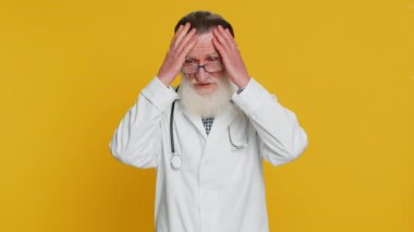 Kıdemli doktor kardiyolog yaşlı adam umutsuzluk ve yalnızlık hissediyor, sinir krizi geçiriyor, kaybediyor, kötü şans kaybı kötü haber, başarısızlık. Eczacı dedesi sarı arka planda izole edilmiş.