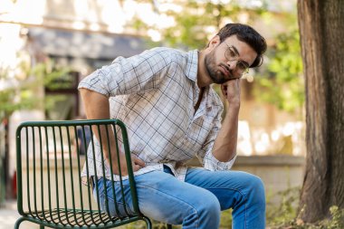 Dışarıdaki mali sorunlardan endişelenen yorgun, üzgün Hintli bir adam. Arap Hintli adam, şehir caddesinde sandalyede oturan borç bütçe kaybını düşünürken hayal kırıklığına uğradı. Yatay