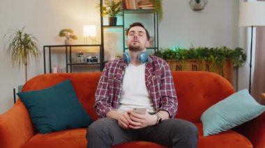 Gürültücü komşuları tarafından rahatsız edilen akıllı telefonlu sinirli beyaz adam kanepede baş ağrısından muzdarip. Evde ince duvarlar, ses yalıtımı olmayan bir daire, tamir işi konsepti. Adam kulağını yastıkla kaplıyor..