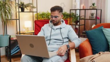 Hintli serbest çalışan adam dizüstü bilgisayarını açar, dizüstü bilgisayarla çalışmaya başlar, e-postalar gönderir, online alışverişler yapar, ev odasında film seyreder. Kameraya bakan gülümseyen adam sandalyeye oturur.