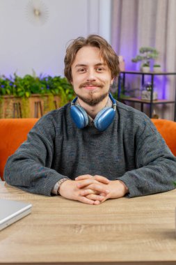 Mutlu sakin sakallı bir adamın portresi masadaki gülümsemesi dostça, mutlu yüz ifadesi başka tarafa bakıyor dinleniyor, rahatlıyor iyi haberler veriyor, zaferi kutluyor. Ofisteki genç adam. Dikey