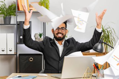 Stresli Hintli işadamı ödenmemiş banka borçlarına bakıyor, evrak işleriyle uğraşıyor, bütçe planlıyor, ev kredisi ödemelerini hesaplıyor. Memnuniyetsiz serbest çalışan adam kağıt para fırlatıyor.