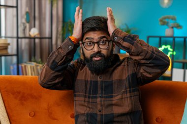 Ne diyecegimi bilmiyorum. Kafası karışmış Hintli bir adam belirsiz bir soru hakkında utanmış, kuşkuları var, hiçbir fikri yok, bilgisiz ve kararsız. Kanepede oturan üzgün, genç İspanyol adam..