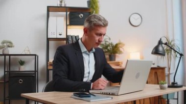 Dizüstü bilgisayar ağı üzerinde çalışan genç, beyaz bir işadamı. Ani zaferle gülümsüyor, gol başarısı, galibiyet, kariyer haberleri. Takım elbiseli serbest çalışan heyecanlı bir adam çalışma masasında oturuyor.