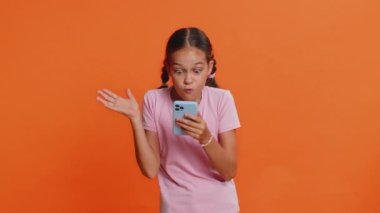 Genç kız çocuk cep telefonuyla yazı yazarak 