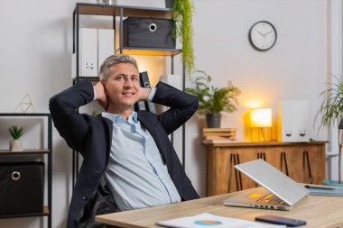 Genç işadamı ofis projesini bitirdikten sonra bilgisayarını kapatıp masa başında oturuyor. Kafkasyalı serbest çalışan, modern ofiste uzaktan kumandalı iş yapıyor. Netbook bilgisayarında gezinme, E-öğrenme İnternet.