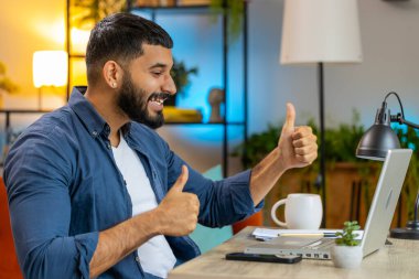 Dizüstü bilgisayarda çalışan mutlu Hintli adam aniden kazanılan galibiyeti, başarıyı, gol başarısını, iyi kariyer haberlerini kutluyor. Ev ofis çalışma masasında heyecanlı bir Arap serbest çalışanı..