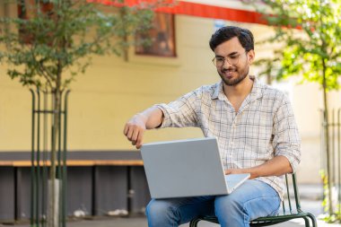 Sandalyede oturan Hintli serbest yazar dizüstü bilgisayarını açar teneffüste internet üzerinden iş arama web sitesinde sohbet etmeye başlar. Genç adam netbook ekranına bakıyor, mesajlar gönderiyor, film izliyor..