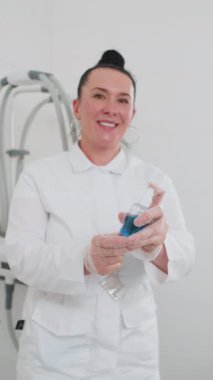 Güzellik salonunda kozmetolog cilt hücresi yenilenmesi için yağ bazlı sprey solüsyonu uygulamaya hazırlanıyor. Nemlendirici maske güzellik kliniğindeki kabuk soyma tedavisinden sonra deriyi sakinleştirmek için kullanılır.