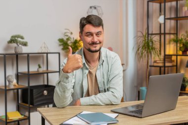 Gibi. Mutlu, heyecanlı, beyaz bir adam kameraya bakıp olumlu bir işaret veriyor. İyi haber, olumlu geri bildirim. Genç adam ofis masasında oturuyor. Yaşam biçimi.