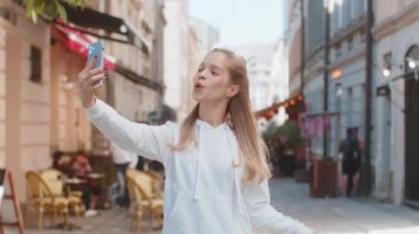 Kafkasyalı neşeli kadın şehir merkezini geziyor, caddeleri geziyor, görüntülü konuşuyor, sohbet ediyor, telefon görüşmeleri yapıyor, turizm sitelerine girip kameralara bakıyor, gülümseyen kız tatillerine gidiyor..