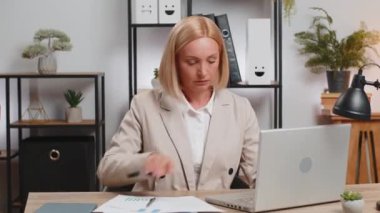 Finansal grafik belgeleriyle çalışan Kafkasyalı olgun serbest muhasebeci, çizelgeler için vergileri hesaplıyor ve ofis masasında raporlar hazırlıyor. Dizüstü bilgisayarda çalışan iş kadını, harcama bütçesi planlaması.