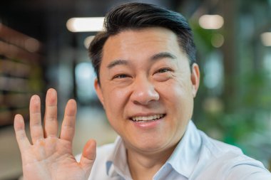 Hoş geldiniz. Mutlu Çinli işadamının yakın plan portresi el sallayarak selam veriyor. İnternetteki Webinar, uzaktan kumandalı sohbet eden birine hoş geldin diyor. Girişimci resmi olarak ofis lobisinde..