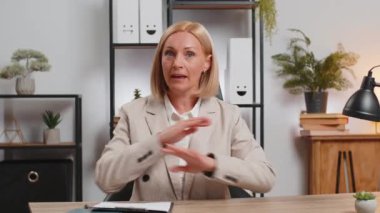Olgun iş kadınlarının POV 'u ofis masasında çalışan, patron, öğretmen ile online iletişim videosu hakkında konuşuyor. Kafkasyalı serbest çalışan kadın kameraya bakıyor. Web kamerası görünümü