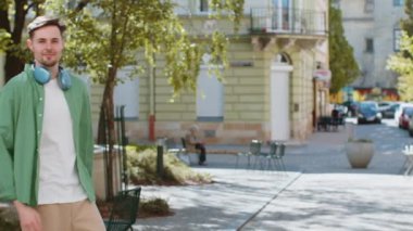 Heyecanlı mutlu gezgin bağırıyor, başarıyı kutluyor, kazanıyor, gol başarısı, iyi haber, piyango talihi, açık havada zafer. Şehir Güneşi Sokağı 'nda yürüyen genç bir adam. Yaşam Tarzları.