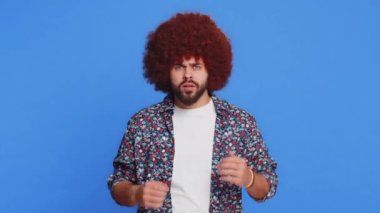 Buna bakmak istemiyorum, çok kötü. Afro saç stili peruklu, elinde jestle gözlerini kapayan korkmuş, utangaç, izlemeyi reddeden korkmuş bir adam. Mavi arka planda izole edilmiş şık bir adam.