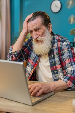 Hüsrana uğramış yetişkin bir adam dizüstü bilgisayarla yazılım sorunları yaşıyor sinirli bir adam hata görüyor ya da bilgisayar ekranında hata bildirimi yapıyor çılgın büyükbaba virüs saldırısı ya da uygulama arızası yaşıyor.