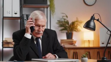 Kafkasyalı kıdemli işadamı ofis masasında cep telefonuyla konuşuyor. Büyükbaba müdürü, ofisteyken takım elbiseli mutlu bir adam elinde akıllı telefon tutuyor. İstihdam, meslek.