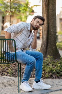 Dışarıdaki mali sorunlardan endişelenen yorgun, üzgün Hintli bir adam. Arap Hintli adam, şehir caddesinde sandalyede oturan borç bütçe kaybını düşünürken hayal kırıklığına uğradı. Dikey