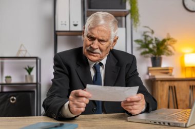 Mektupta kötü haber okuyan kıdemli işadamı şok oldu. Finansal sorunlar, banka borç ödeme faturası, vergi faturası veya iflas bildirimi. Ofis masasındaki takım elbiseli adam.