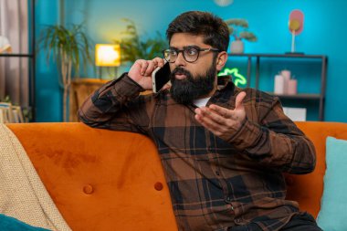 Tartışma. Öfkeli kızgın işadamı, evdeki koltukta hararetli telefon konuşmalarına girişiyor. Sinirli patron, astlarıyla tartışan cep telefonu yöneticisini kullanarak hayal kırıklığını ifade ediyor. Yaşam biçimi