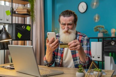 Masada elinde akıllı telefon ve kredi kartı somurtmalarıyla oturan kızgın son sınıf öğrencisi ödemeyi internet üzerinden yapmaya çalışıyor. Parasızlık, yetersiz kaynak. Dolandırıcılık kurbanı.