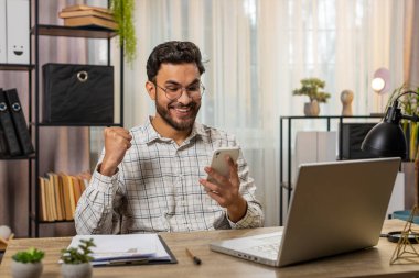 Akıllı telefon daktilo kullanarak mutlu Hintli işadamı, 