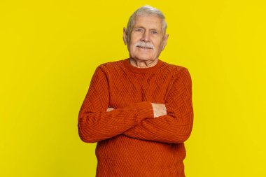 Mutlu yaşlı bir adamın portresi dostça gülümsüyor, kameraya bakan mutlu yüz ifadesi hayal kuruyor, dinleniyor, rahatlıyor iyi haberler veriyor. Sarı arka planda yaşlı büyükbaba emekli.