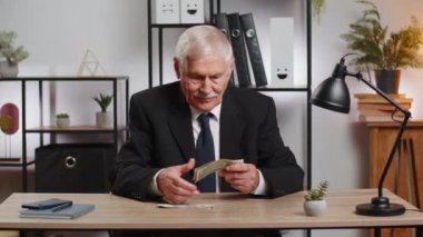 Kafkasyalı kıdemli iş adamı nakit paraları sayarak serbest çalışıyor. Finansal kriz. İflas. Yoksulluk ve yoksulluk. Takım elbiseli büyükbaba ofis masasında oturuyor..