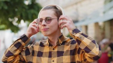 Neşeli, gevşemiş, coşkulu genç adam dışarıda dans eden enerjik disko rock n roll müziğini seçiyor. Yetişkin bir adam kablosuz kulaklıklarını çıkarıyor. Şehrin caddesinde gülümseyen kameraya bakıyor..