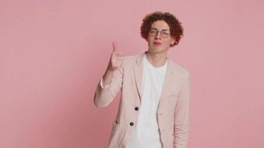 Aferin, aferin. Ceketli, beyaz, kıvırcık saçlı, gururlu adam alkışlıyor ve onaylıyor. Başarılı, mükemmel bir iş, olumlu geri bildirim, tamam. İçerideki pembe arka planda izole edilmiş genç adam.