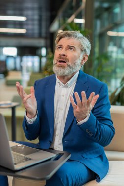 Kafkasyalı bunalımlı iş adamı maddi sorunlar hakkında endişeli. Stresli takım elbiseli adam hayal kırıklığına uğramış görünüyor. Para borcunu, kötü günü, bütçe kaybını, iflası modern ofis lobisinde oturuyor.