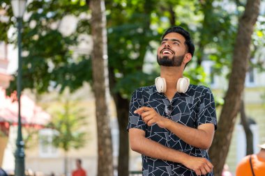 Düşünceli, düşünceli, düşünceli, düşünceli, genç Hintli bir adam. Düşünceli bir ifadeyle, bir çözüm düşünüyor, şüpheci bir soru soruyor, dışarıda hayaller kuruyor. Sakallı Hintli adam şehir caddesinde. Kasaba yaşam tarzları.