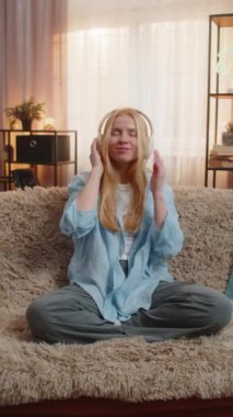 Gün batımında evde müzik dinleyen genç bir kadın, gözleri yavaşça hareket eden ve kurnaz bir gülümsemeyle kapatıyordu. Kanepedeki beyaz kız melodiyi huzurlu bir duruşla hissediyor, neşe ve duygusal rahatlamayı yansıtıyor.