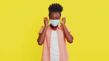 Tıbbi koruyucu maske takan Afro-Amerikalı bir kadın. Ağzı gözle görülür bir yorgunlukla kapatıyor. Sarı arka plandaki hasta siyah kız, hastalık veya rahatsızlık sırasında korunma ve tedbiri vurguladı