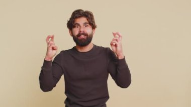 Mutlu Hintli adam bağırıyor, başarıyı kutluyor, kazanıyor, doğum günü, piyango hedefi başarısı, iyi haber, zafer. Genç Hintli adam bej renkli stüdyo arka planında izole edilmiş..