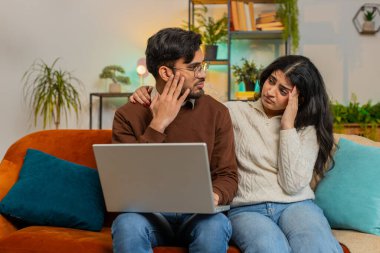 Dizüstü bilgisayar kullanıp evdeki kanepede oturup ağzını kapatan genç çift şok oldu. Hayal kırıklığına uğrayan Hintli aile babası kadın birlikte kötü haber okurken dairede netbook 'ta kaybediyor..