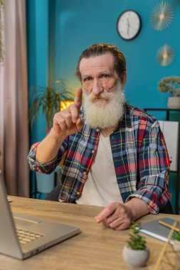 Dizüstü bilgisayarda çalışan kıdemli adam el sıkışıyor ve 