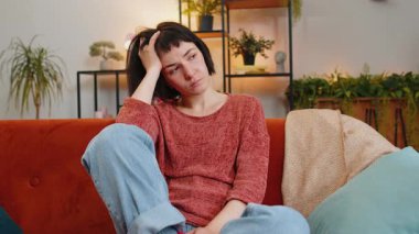 Üzgün, yalnız, beyaz bir kız hayatı hakkında düşünceli görünüyor. Kanepede otururken adaletsiz bir durumdan muzdarip. Eli saçı olan üzgün bir kadın evdeki oturma odasında kendini kötü hissediyor.