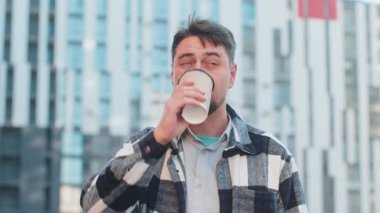 Mutlu Kafkasyalı olgun bir adam sabah kahvesinin tadını çıkarıyor sıcak içecek ve dışarıda gülümsüyor. Dinleniyorum, ara veriyorum. Şehir merkezindeki caddede dikilen ve kahve içen adam. Kasaba yaşam tarzları.