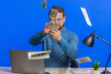 Kafkasyalı zengin adam para harcayıp daha fazla bahşiş dağıtıyor daha fazla bahşiş veriyor büyük ikramiye kazanıyor kumarhane ikramiyesi kazanıyor, başarılı bir alışveriş ödemesi yapıyor. Mavi arkaplanda izole edilmiş adam