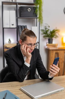 Kafkas asıllı genç adam akıllı telefon daktilosu kullanıyor, aniden piyango sonuçlarını kaybediyor, kötü haber, ofis masasında servet kaybı. Sinirli serbest çalışan işçi..