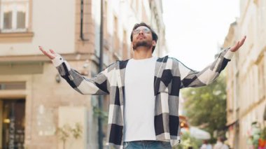 Sakin ol, sakin ol. Genç Hintli adam meditasyon yapıyor, derin derin nefes alıyor, dua eden gözler kapalı, konsantre düşünceler, dışarıda huzurlu bir zihin. Şehir caddesinde mola veren bir adam..