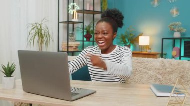 Afrikalı Amerikalı kadın online e-postayla iyi haberler alıyor. Zaferi kutlamak, gülümsemek, neşeli bir ifade, evde oturmak. Laptop ekranını izlemek, mutlu ve heyecanlı hissetmek, içeride pozitif enerji.