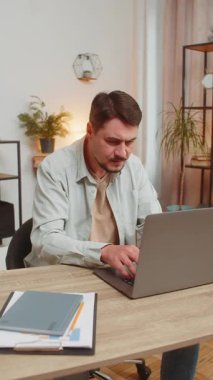 Evde çalışırken bilgisayar kullanan öfkeli, serbest çalışan bir adam iş yerinde sinir krizi geçiriyor, stres yönetimi, zihinsel stres sorunları, kendini kaybetmek, başarısızlığa tepki vermek. Dikey.