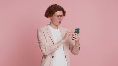 Üzgün Kafkasyalı adam akıllı telefon daktilo kullanıyor, oyun oynuyor, kaybediyor, ani piyango sonuçlarına şaşırıyor kötü şans kaybı şanssız haber. Pembe arka planda izole edilmiş yakışıklı çekici bir adam.