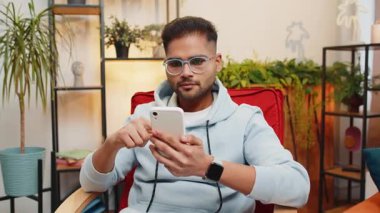 Mutlu Hintli adam cep telefonu daktilo kullanarak 